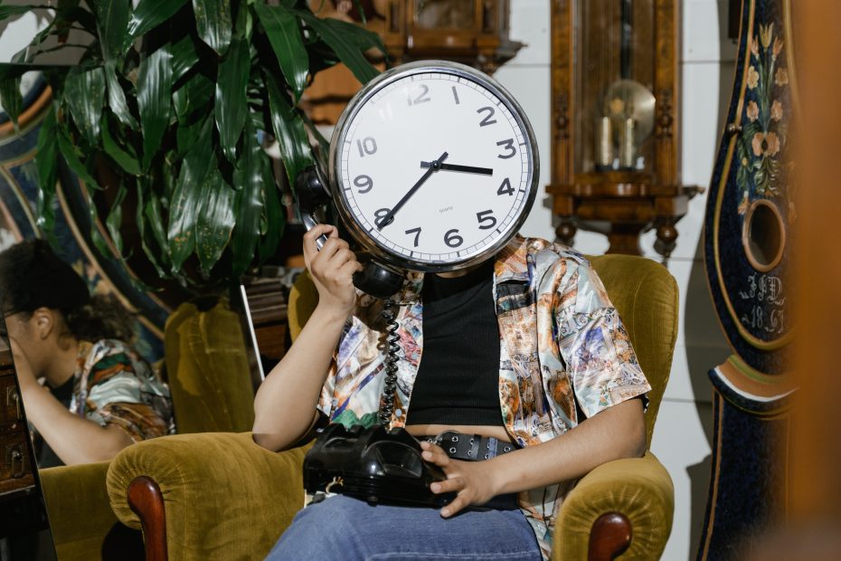 Person on phone with a clock as a face.